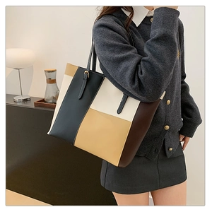 Detail view of the four-color patchwork tote bag with adjustable metal buckle straps