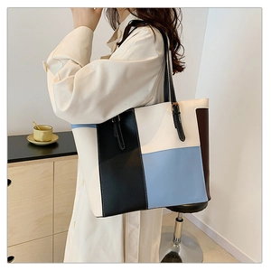 Detail of multi-color patchwork PU leather tote bag with long black handles and modern style