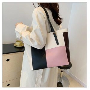 Macro view of multi-color paneled tote bag featuring adjustable black straps and PU leather