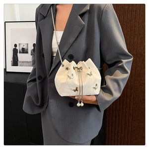 White pleated bucket bag with silver butterfly charms and pearl drawstring details