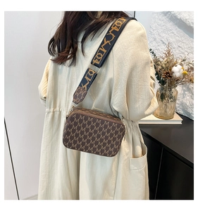 Detail of brown monogram shoulder bag with wide textile strap and double zipper closure