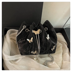 Detail of black pleated bucket bag with silver butterfly charms and pearl drawstring