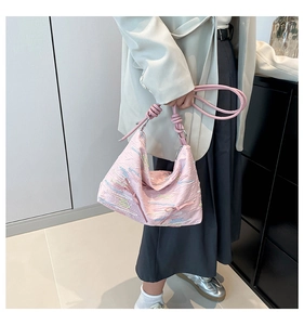 Detailed view of pink pleated hobo bag with colorful wave embroidery and knotted strap