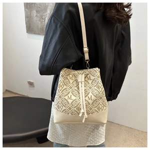 Model view of cream bucket bag with ML 1987 monogram print and drawstring detail