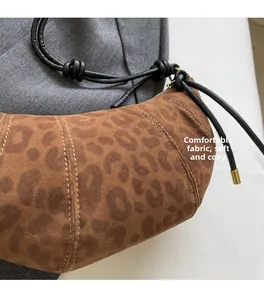 Macro shot of leopard print crescent bag with soft fabric and knotted strap detail