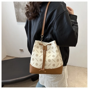 Close-up of the monogram drawstring bucket bag featuring leather trim and metal hooks