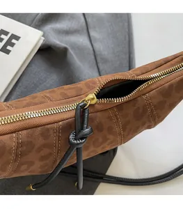 Detailed macro view of brown leopard print bag with gold zipper and knotted puller detail