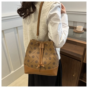 Close-up of brown bucket bag with monogram print leather and adjustable strap