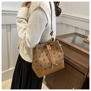 Detail showing vintage brown monogram bucket bag with drawstring closure and leather base