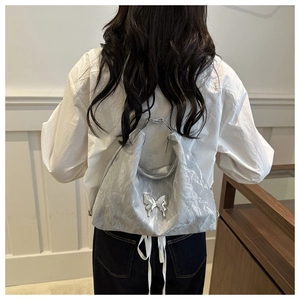 Silver metallic bow hobo bag with unique butterfly buckle shown on model back