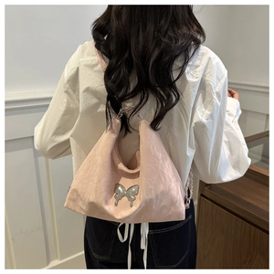 Vue arrière d'un sac plissé rose avec papillon argenté et bandoulière chaîne sur mannequin