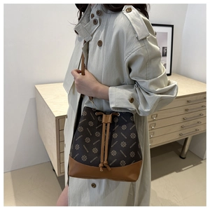Detailed view of coffee printed drawstring bucket bag with caramel base and gold hardware