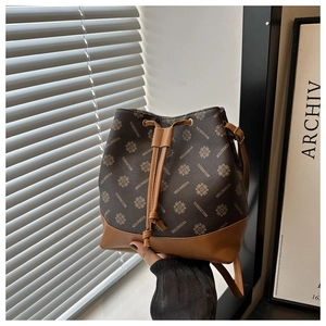 Detail view of a vintage drawstring bucket bag with monogram leather and premium stitching