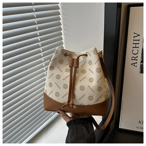 Detail of vintage bucket bag featuring floral letter print and brown leather drawstring