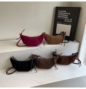 Collection of colorful suede croissant bags and leopard print crossbody bags on stairs
