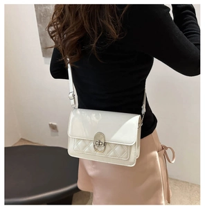 Detail van de crèmekleurige laklederen crossbodytas met klassiek ruitvormig stiksel