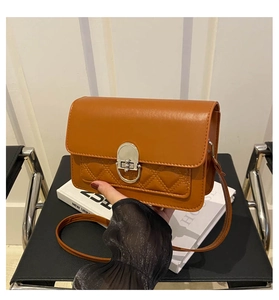 Detail van de doorgestikte crossbodytas van karamel leer met zilveren ronde sluiting