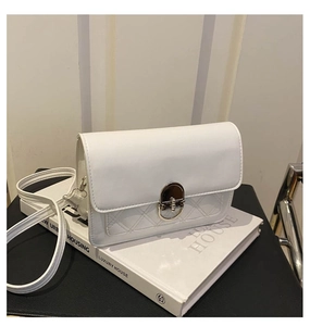 Detail van witte crossbodytas met ruitstiksel en zilveren metalen draaisluiting