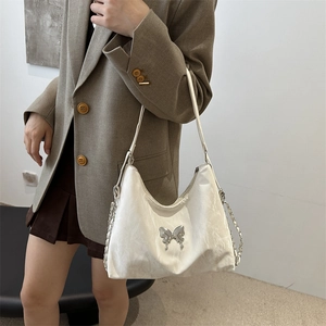 Sac bandoulière blanc plissé avec boucle papillon argentée et sangle en chaîne