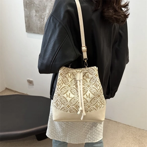 Vintage monogram bucket bag with drawstring closure and slim shoulder strap in beige