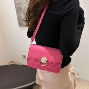 Fuchsia crossbodytas met gewatteerd patroon en zilveren sluiting gedragen door model