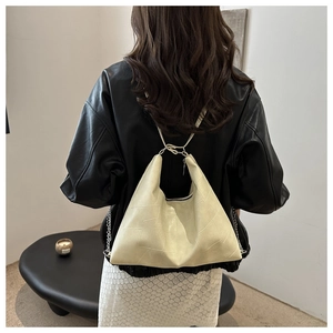 Détail du sac crème avec motif géométrique et bandoulière en chaîne argentée