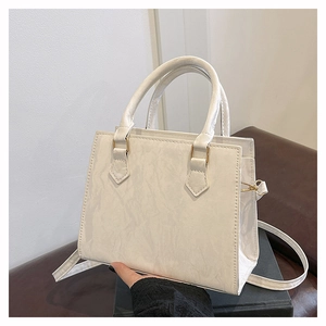 Detail view of beige tote bag featuring vintage wrinkled texture and dual handles