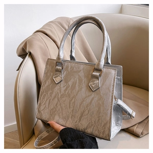 Detail of silver grey tote bag with pleated texture and adjustable shoulder strap