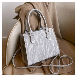 Detail of grey tote bag showing wrinkled leather texture and light gold hardware