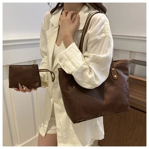 Detail of dark brown tote bag set with geometric stitching and gold rivet accents