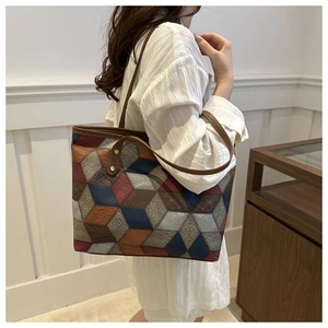 Detail view of large tote bag with multi-colored geometric pattern and textured PU leather