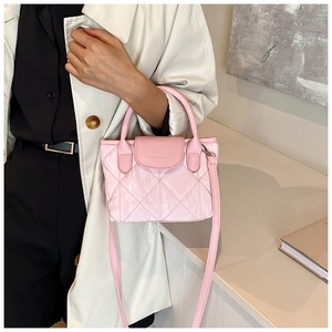 Pink quilted bucket bag with crossbody strap shown as a stylish handbag on a model