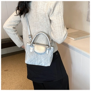 Silver quilted crossbody bag detail showing metallic finish and pleated texture on model