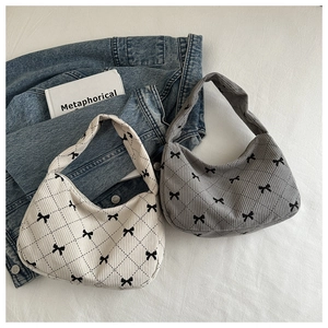 Detail of corduroy hobo bags with diamond quilting and bow accents on a casual background