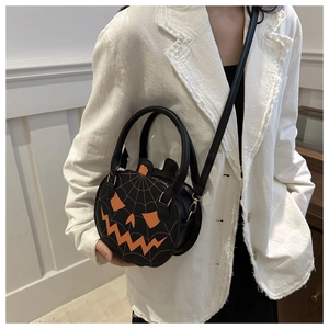 Detail of Halloween pumpkin crossbody bag with orange face and spider web embroidery