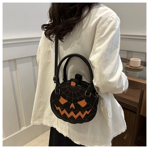 Detail of round pumpkin bag showing orange face embroidery and spider web stitching