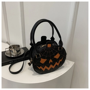 Detail of pumpkin-shaped crossbody bag with orange facial expression and spiderweb stitching
