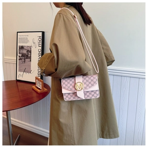 Detail of pink monogram pattern small square bag with golden M buckle and striped strap