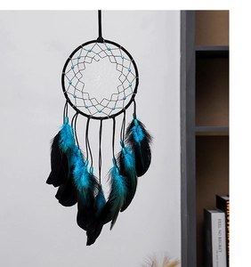 Détail de l'attrape-rêves avec plumes bleues et noires et filet blanc aux perles