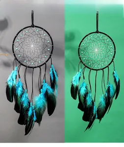 Détail d'un attrape-rêves artisanal avec des plumes bleues et un tissage étoilé