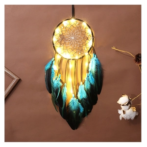Détail de plumes bleues et noires sur un attrape-rêves avec lumières LED chaudes