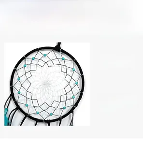 Détail de la maille tissée main avec perles turquoise et plumes bleues sur l'attrape-rêve