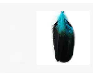 Détail de plumes décoratives turquoise et noires avec perle bleue pour travaux manuels