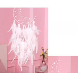 Close-up of pink crescent moon dreamcatcher with soft feathers and delicate bead details