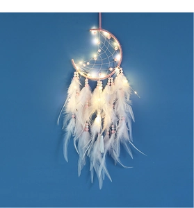 Macro detail of moon-shaped dream catcher with white feathers and glowing LED lights