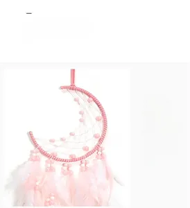 Detail of moon-shaped pink dream catcher with soft feathers and handcrafted beads