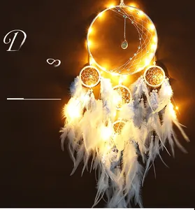 Detail of dream catcher with soft white feathers and warm yellow LED string lights