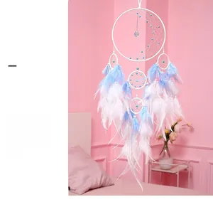 Handcrafted dreamcatcher with pink and blue feathers hanging in a cozy bedroom