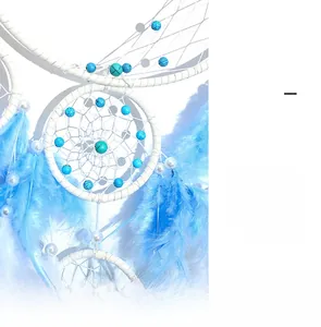 Detail of light blue and white dream catcher with feathers, beads, and delicate shadow