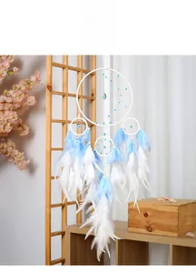Detail of multi-ring dreamcatcher with white and blue feathers and bead decorations